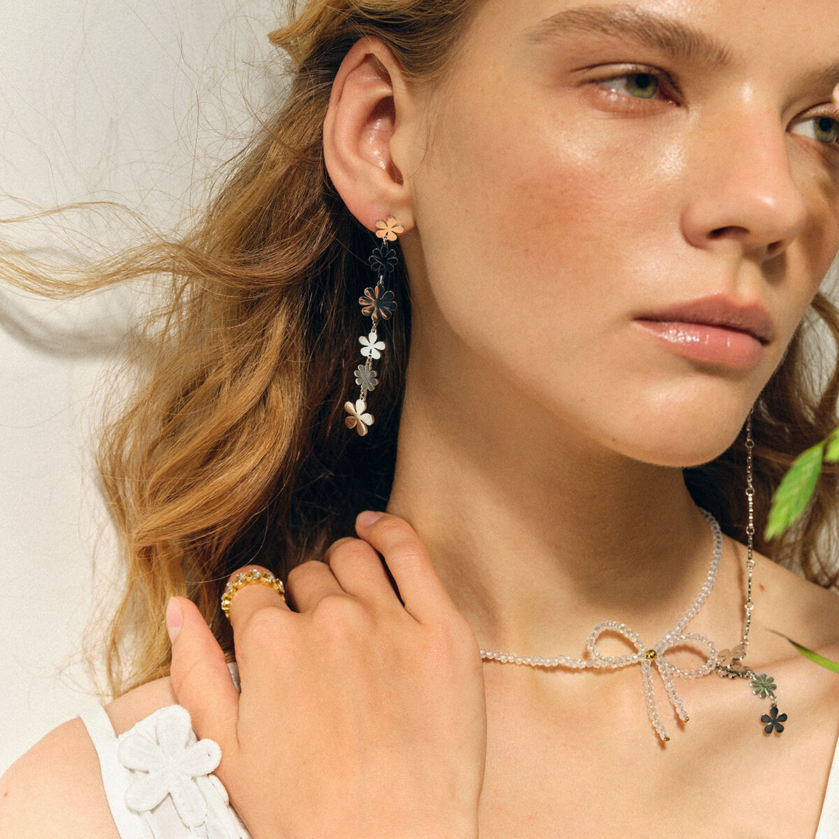 Boucles d'oreilles pendantes asymétriques en acier inoxydable doré, ornées de petites marguerites et d'un pompon élégant. h5 Image3
