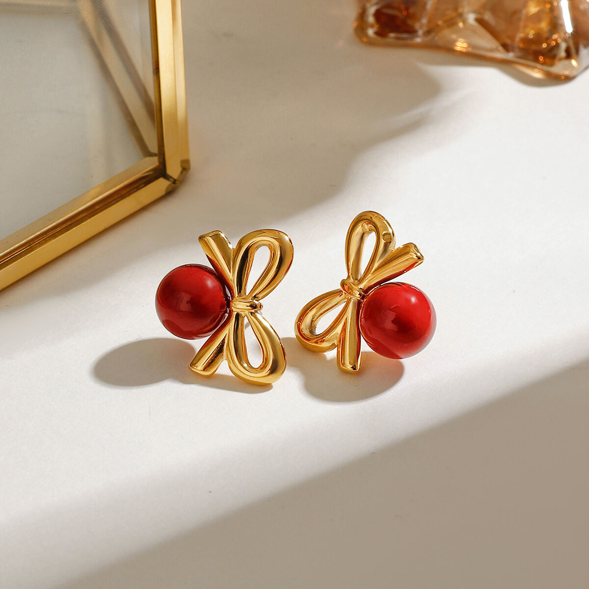 1 paio di splendidi orecchini a bottone da donna in acciaio inossidabile color oro con fiocco retrò e sfera rossa 2