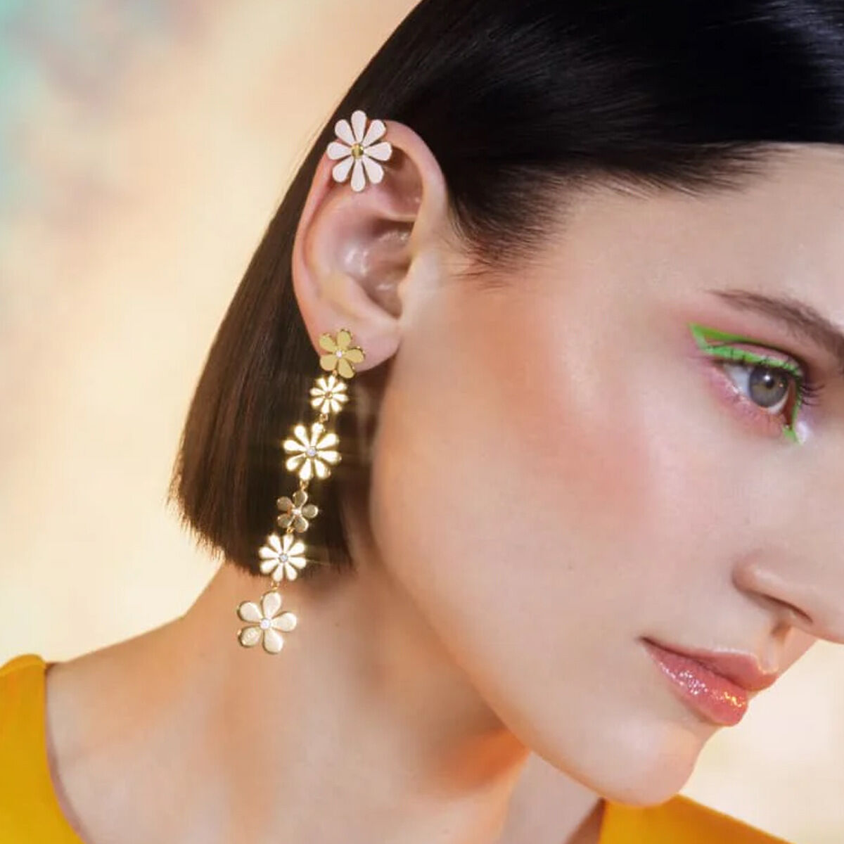 Boucles d'oreilles pendantes asymétriques en acier inoxydable doré, ornées de petites marguerites et d'un pompon élégant. Image5