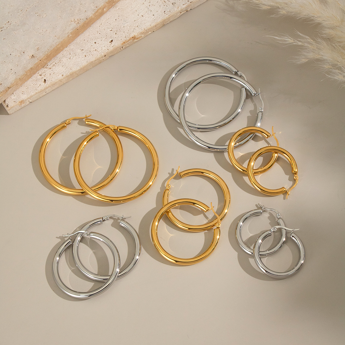 1 par de pendientes de aro básicos circulares de acero inoxidable, resistentes al agua, de color dorado.