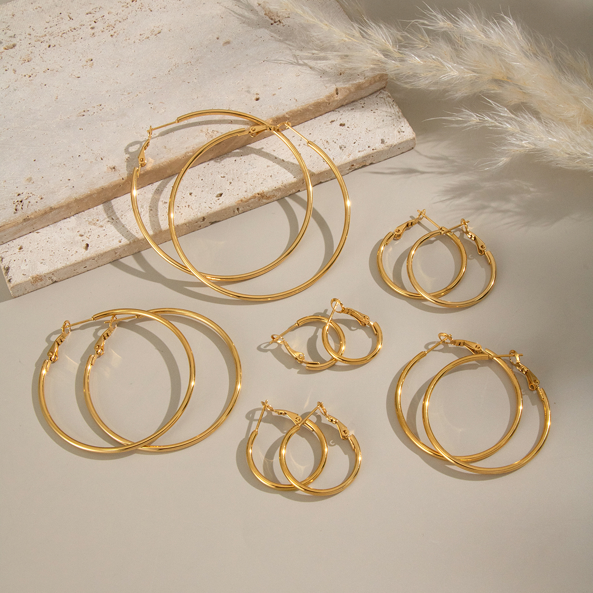 1 par de pendientes de aro básicos circulares de acero inoxidable, resistentes al agua, de color dorado.
