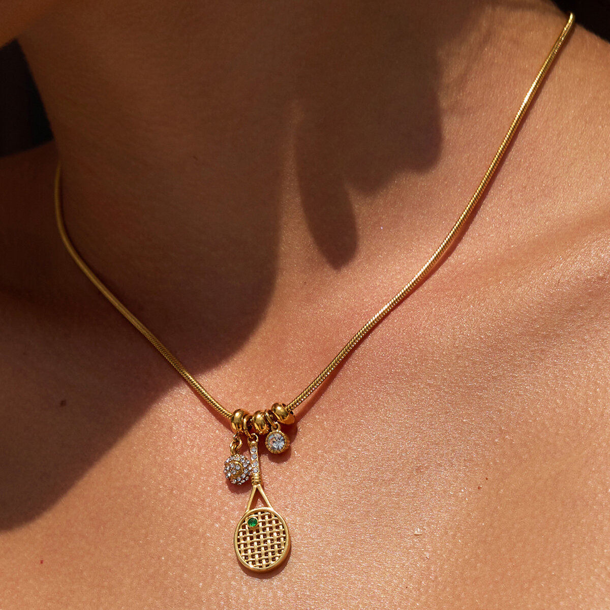 Collar con colgante para mujer con forma de raqueta de tenis, de acero inoxidable, resistente al agua y de color dorado con circonitas.
