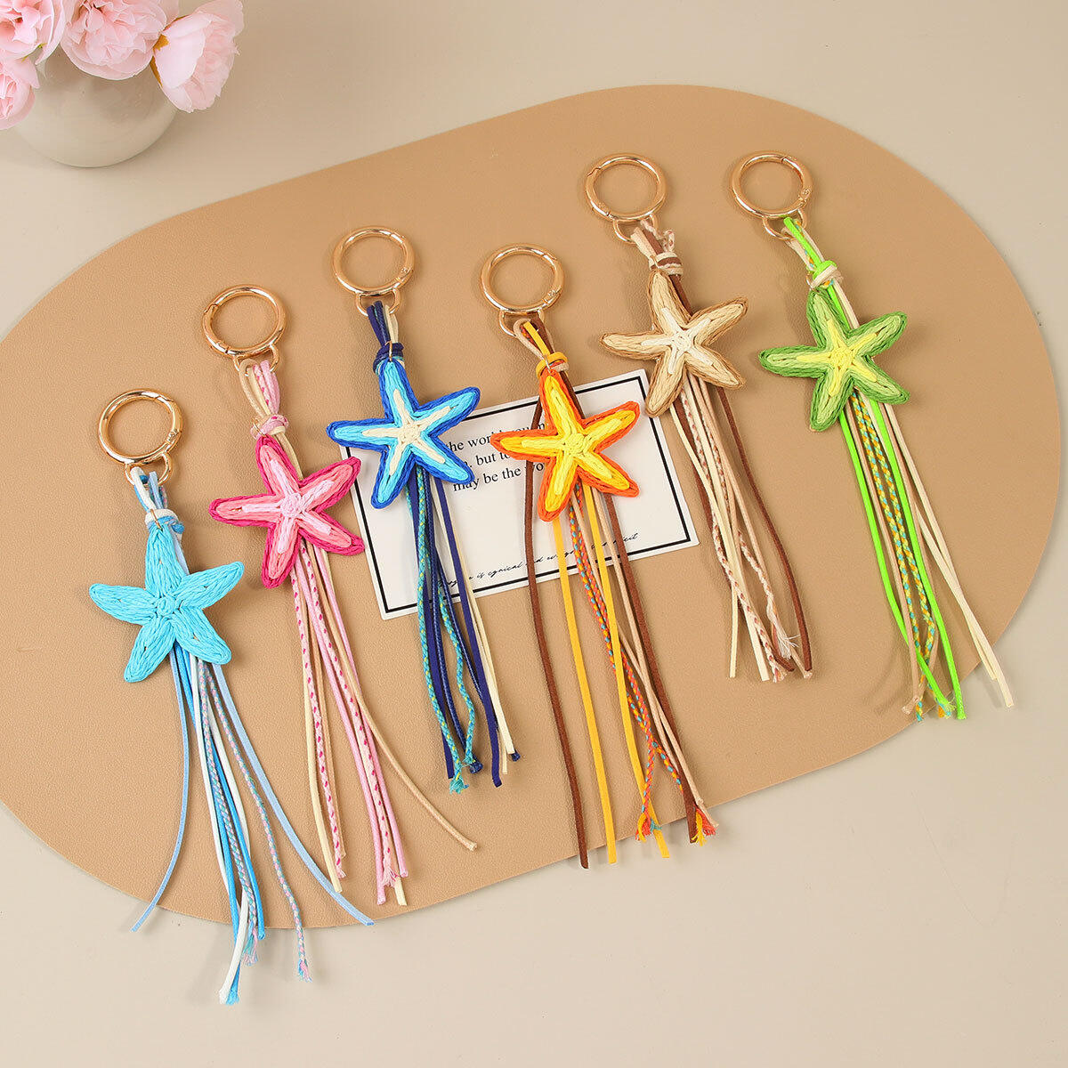 Eenvoudige serie vakantie tashangers van geweven raffia in verschillende kleuren met zeesterrenmotief.