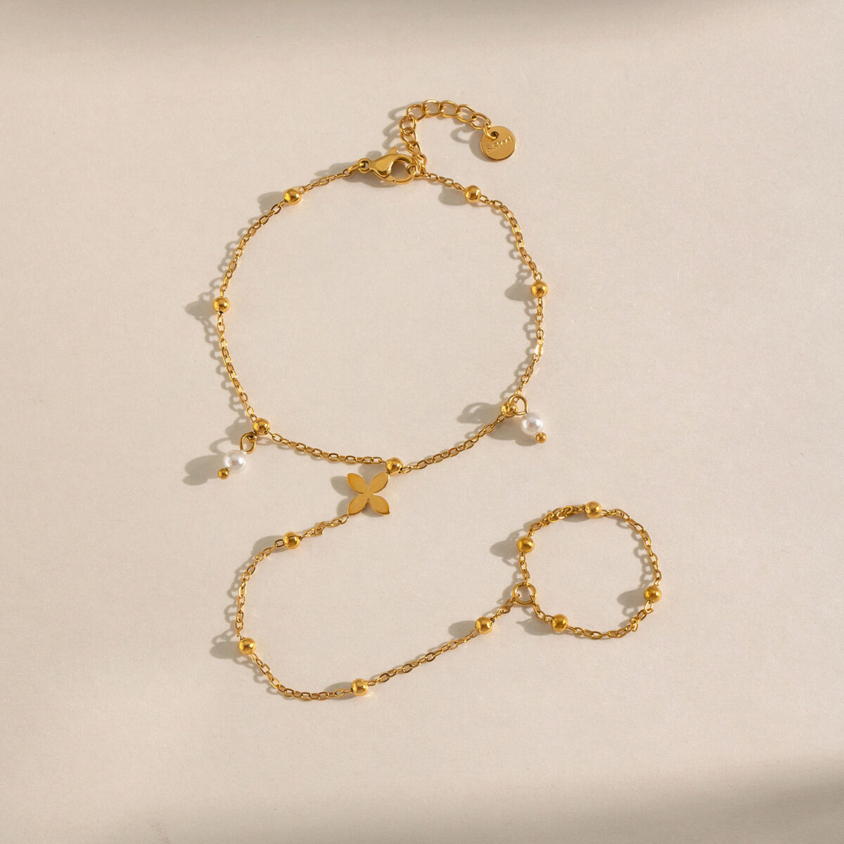 Cadena de mano para mujer de acero inoxidable impermeable con forma de trébol y perlas artificiales color dorado.