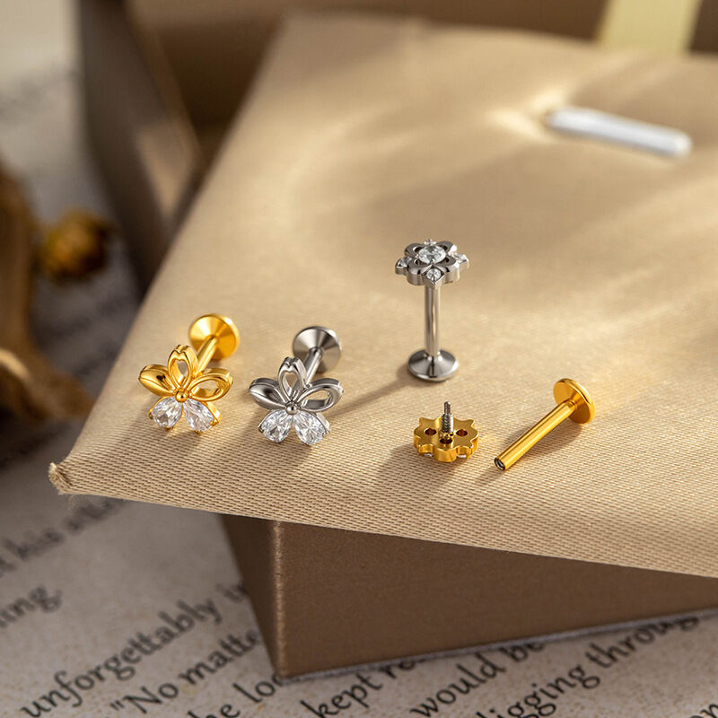Pendientes de mujer con diseño de flor sencilla, aleación de titanio color oro y circonita. Imagen3