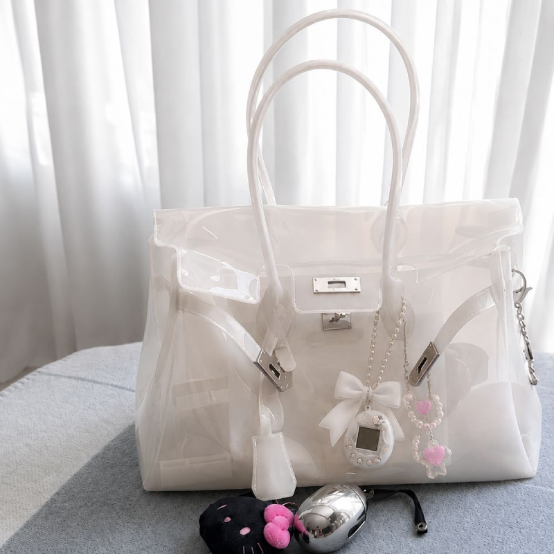 Sac carré femme en PVC transparent uni avec détails métalliques et fermetures métalliques, style décontracté.