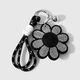 Un llavero con forma de flor plateada y negra. Imagen6